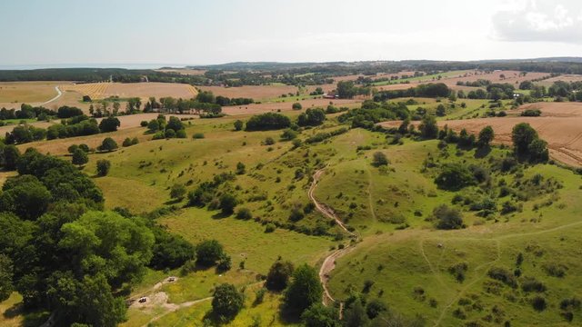 Aerial view over the idyllic Swedish hills Brosarps backar on Osterlen in Skane, Sweden. Open fields and hiking trails