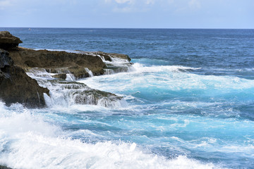 Fototapeta na wymiar Devil's Tears is a rocky outcrop with large crashing waves which is located on a small island off the south east coast of Bali known as Nusa Lembongan, Indonesia