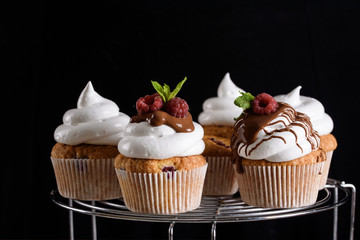 The process of making cupcakes, coating a cream from a pastry bag in the hands of a pastry chef.