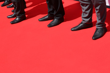 Men's feet in shoes on the red carpet