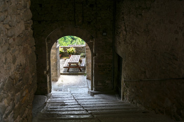 Obraz premium Narrow dark footpath under the houses to a panoramic terrace in Virgoletta, a beautiful ancient mountain village, district of Villafranca in Lunigiana, Tuscany, Italy