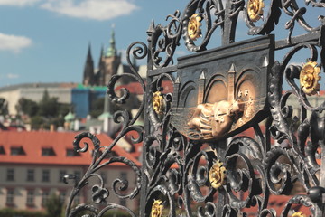 Image of Saint John of Nepomuk on Charles Bridge with Prague Castle in the background.