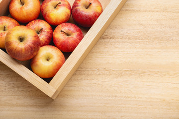 Fresh apple background with copy space. Red apples in crate on wooden table