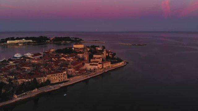 Drone reveal shot old city and island with sea, ocean. Sunrise with beautiful light, 4K
