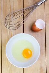 TOP VIEW OF YELLOW EGG IN PLATE AND BEVERING ON WOODEN TABLE