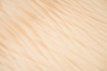 Natural textured background of wave patterns in golden sand in a full frame abstract close up