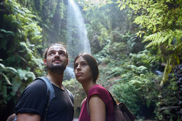 Young couple standing in front of a waterfall