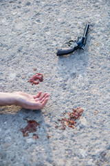 gun and hand at murder scene