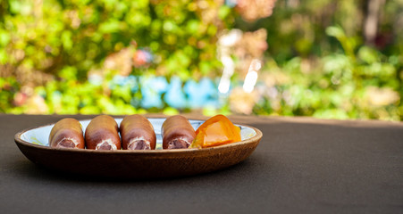 sausages on a plate on green garden background
