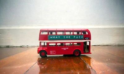 Photo sur Plexiglas Bus rouge de Londres bus jouet sur un plancher en bois avec un message