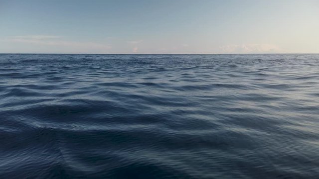View of calm ocean water surface with small waves and empty horizon, slow motion