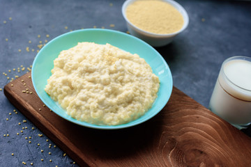 millet porridge in a plate on a wooden Board on a dark background. healthy diet.