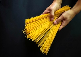 italian pasta in hand on black background