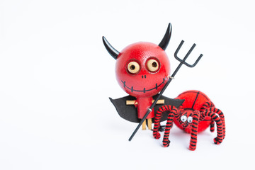 Halloween decoration object on white background, wooden red devil doll with red yarn spider isolate...