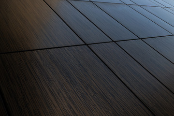 Diagonal view of dark brown venge tile wall surface, wood imitation texture