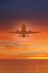 Silhouette of plane in the sky above Sea at Sunset. travel, flight, vacation Concept. Low key photo. relax time