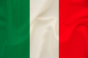 The national flag of the country of Italy on gentle silk with wind folds, travel concept, immigration, politics, copy space, close-up