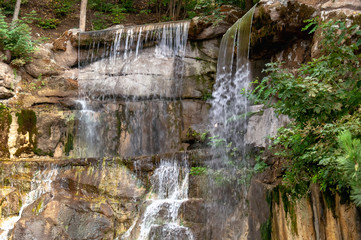 Fototapeta na wymiar Waterfall in the park close-up. Mountain waterfall.