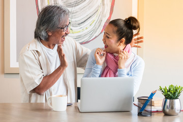 Obraz premium Senior couple are working at home using computers and laptops, with the internet communicating online with other people.