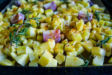 Primo piano di una teglia di patate, cipolle e aglio al forno, ricette e cucina