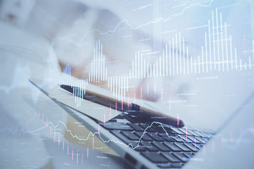 Stock market graph on background with desk and personal computer. Double exposure. Concept of financial analysis.