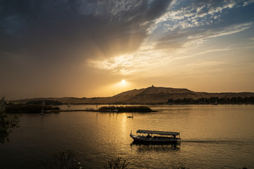 Tourist boats sailing along the Nile River at sunset, Aswan, Egypt