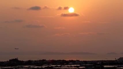 沖縄の夕日と着陸する飛行機