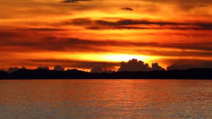 赤く染まる空、沖縄の海に沈みゆく夕日