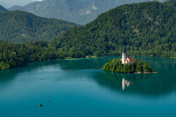 Beautiful landscape of Lake Bled with Pilgrimage Church of the Assumption of Maria with tourist kayaking in the lake.