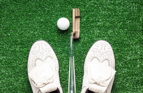 Studio Shot, Flat Lay Of Golf Shoes Putter And Golf Ball On The Green Fake Grass