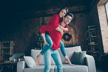 Portrait of romantic couple hug piggyback have christmas x-mas vacation event near couch in house with newyear illumination lights indoors