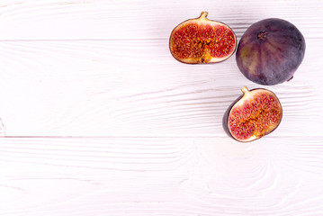 cut figs on white wooden surface top view