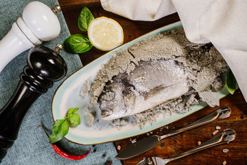 Dish with prepared dorado fish on the wooden background