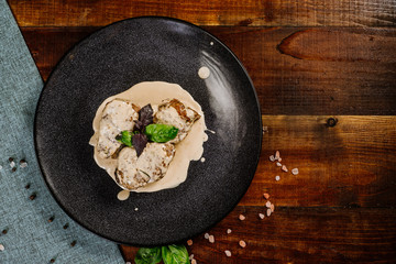 Grilled meat medalions with sauce on the wooden background