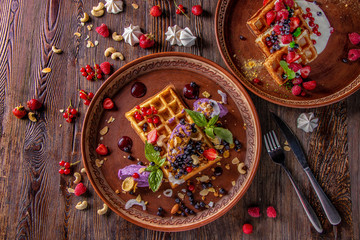 Varieties of Belgian waffles with blueberry cream and cheese cream, granola, nuts and fresh berries, rustic style, Tasty breakfast, Horizontal orientation, Top view
