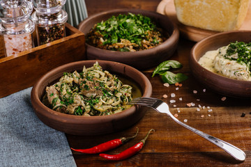 Fototapeta premium Dish with chopped meat with sauce and herbs on the wooden background
