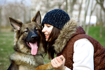 A Cute German Shepherd Dog, Sheepdog Portrait. A Nice, Young Woman is Huging a Little Puppy. A Lovely Friendship Portrait. Shooted in the Autumn, Fall time.