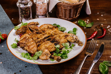 Roasted quail with herbs on the wooden background