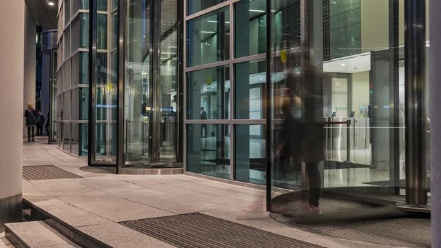  The flow of people passing through the revolving door of the modern office building at the end of the working day,time lapse