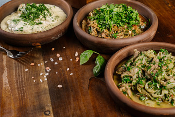 Obraz na płótnie Canvas Dish with chopped meat with sauce and herbs on the wooden background