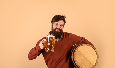 Brewer. Happy brewer holds glass with ale. Handsome bearded man drinking beer. Equipment for preparation of beer. Brewery concept. Man tasting draft beer. Beer pub and bar. Man holds mug of beverage.