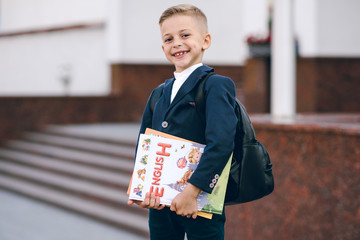Little schoolboy with books in her hand. Back to school.