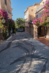 Quiet deserted narrow street in Porto Rotondo Sardenia with flowers and artistic pavement
