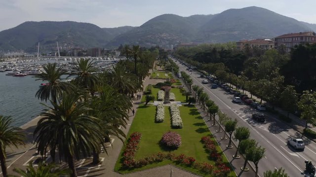 Drone flying over park and busy road near harbor