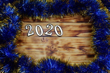 on a wooden surface lies tinsel with numbers 2020