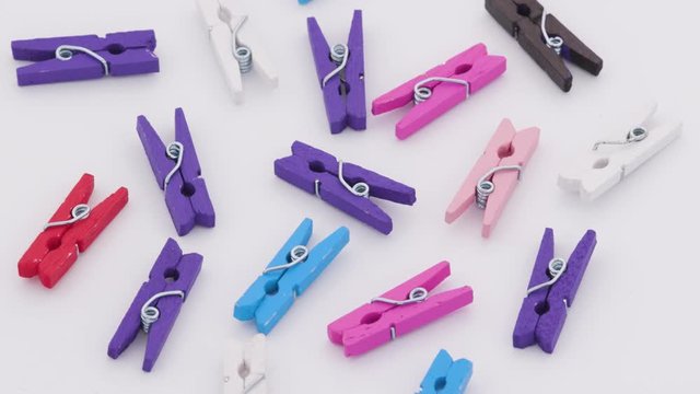 Petites pinces &agrave; linges color&eacute;es tournant sur un support blanc