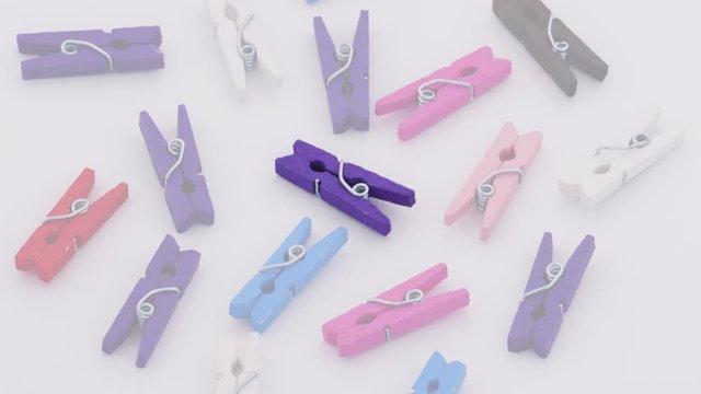 Petites pinces &agrave; linges color&eacute;es tournant sur un support blanc avec mix