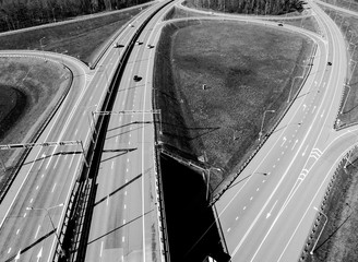 Aerial view of highway and overpass in city. Aerial view of cars crossing interchange overpass....