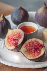 Figs, cheese and honey on a white plate