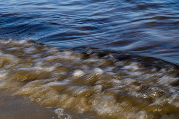 Waves on the seashore captured with a slow shutter speed. Natural abstract motion background.